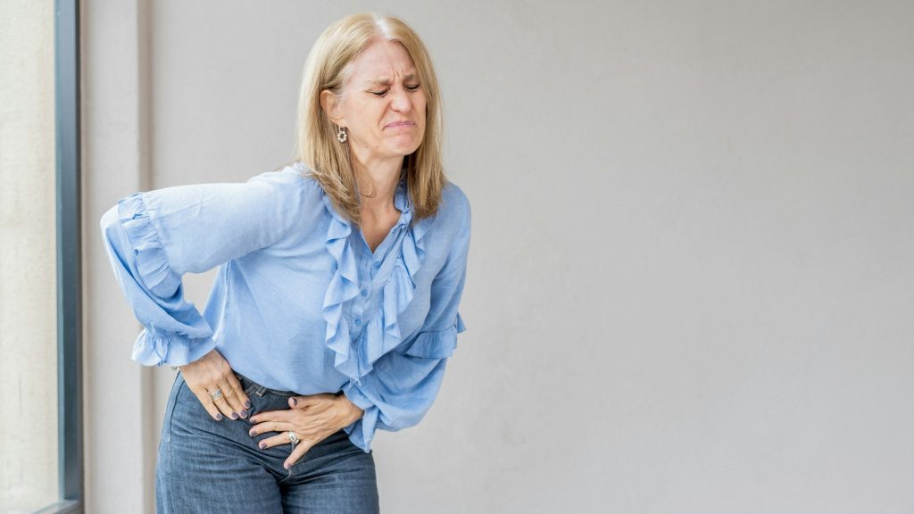 A blonde woman is suffering because she has appendix pain.